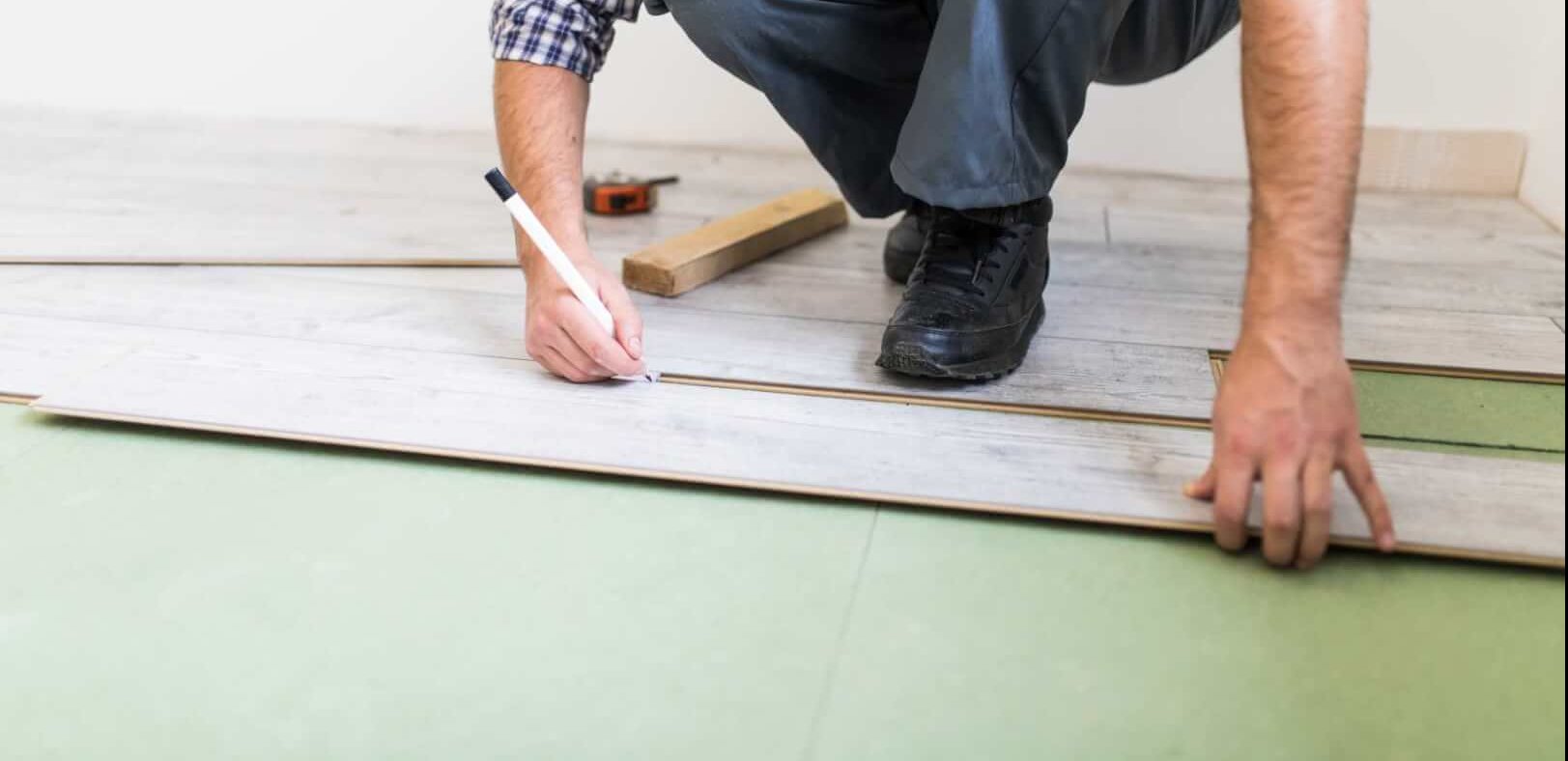 young-worker-lining-floor-with-laminated-flooring-boards (1)